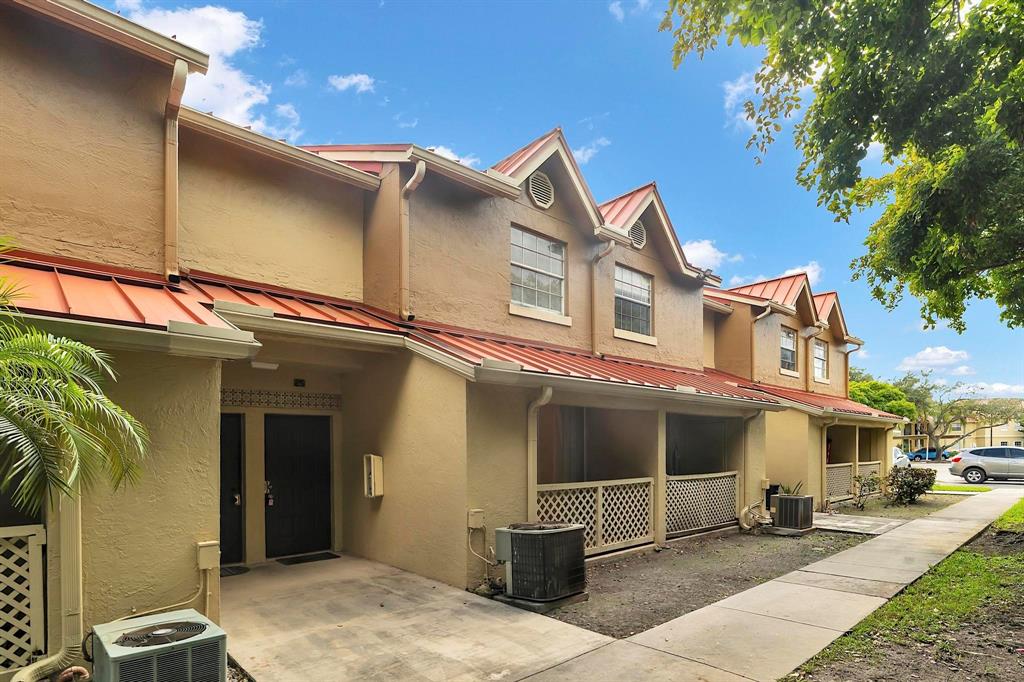 18352 Northwest 68th Avenue, Unit M Hialeah, FL 33015 - Photo 3 of 28 a front view of a house with a garage