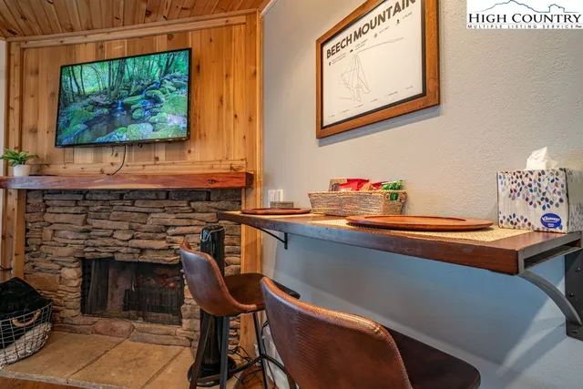 a room with table chairs and a fireplace