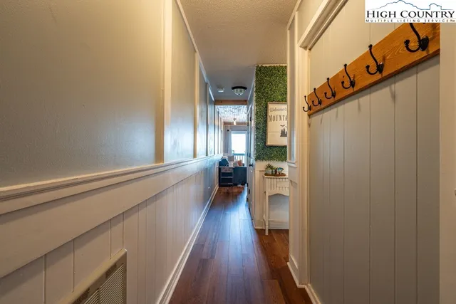 a view of a hallway with wooden floor and staircase
