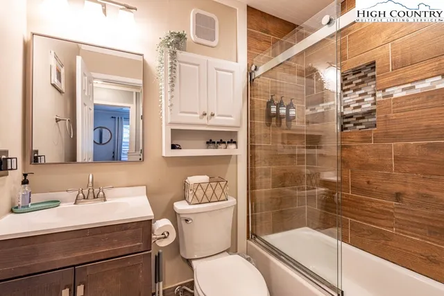 a bathroom with a sink a toilet a mirror and shower