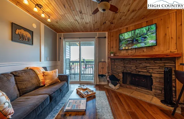 a living room with furniture a flat screen tv and a fireplace