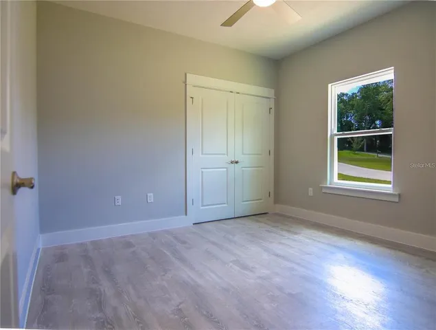 an empty room with windows and closet