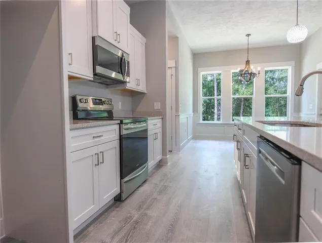 a kitchen with stainless steel appliances kitchen island granite countertop a stove a sink and a microwave
