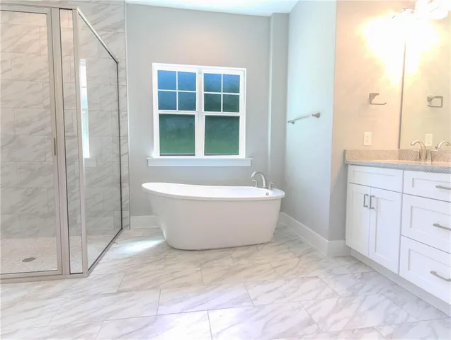 a white bath tub sitting next to a vanity