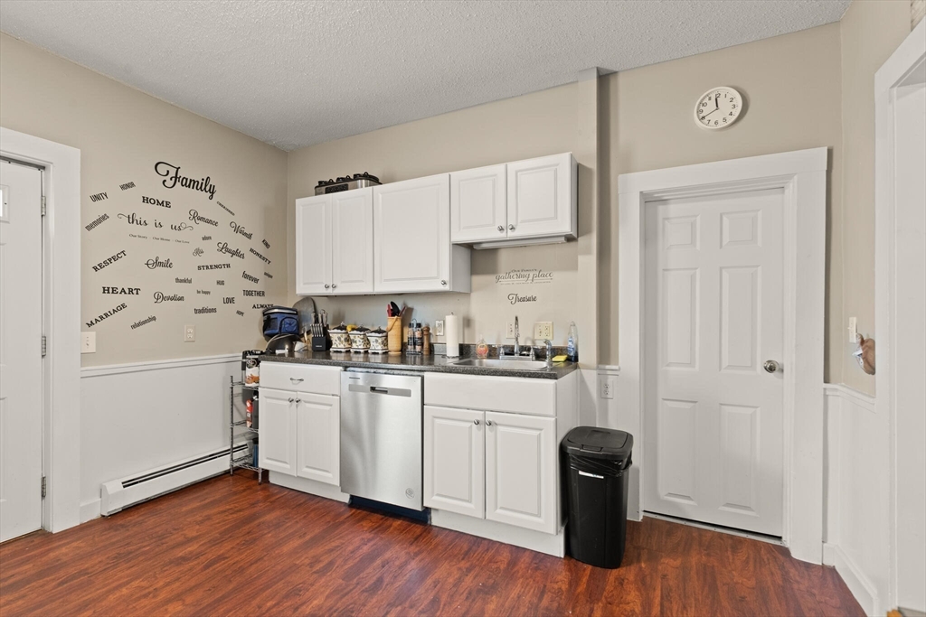245 Rantoul Street Beverly, MA 01915 - Photo 11 of 12 a kitchen with white cabinets and wooden floor