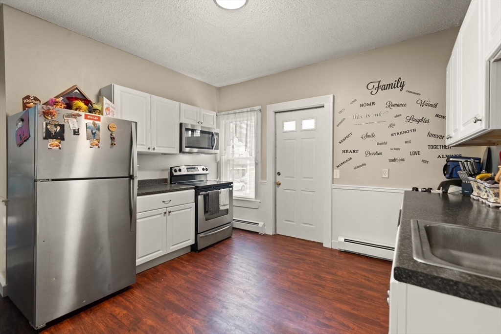245 Rantoul Street Beverly, MA 01915 - Photo 4 of 12 a kitchen with granite countertop stainless steel appliances a refrigerator a stove a sink and a hard wood floor