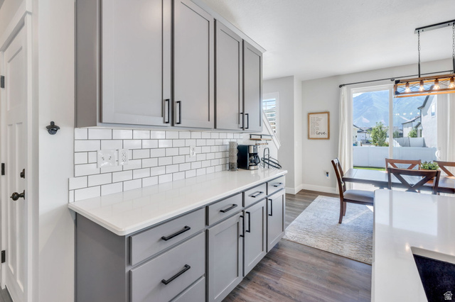 252 North Sunrise Rnch Drive Mapleton, UT 84664 - Photo 22 of 62 Kitchen counter and cabinetry featuring light gray shaker-style cabinets with black hardware, white subway tile backsplash, and a white countertop
