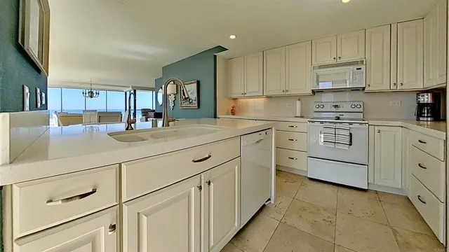 a kitchen with stainless steel appliances kitchen island granite countertop a table chairs sink and cabinets