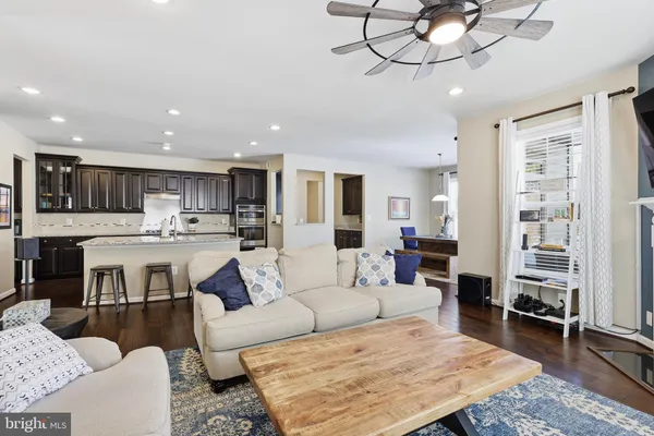 a living room with furniture kitchen view and a chandelier