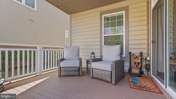 a view of a swimming pool with a bench and trees in the background