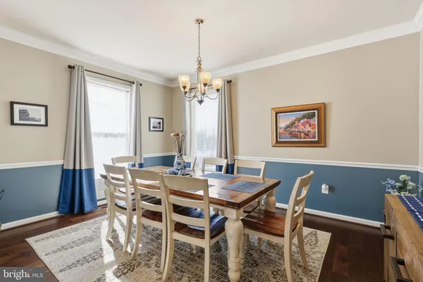 a kitchen with stainless steel appliances granite countertop a refrigerator a stove top oven a sink dishwasher and white cabinets with wooden floor