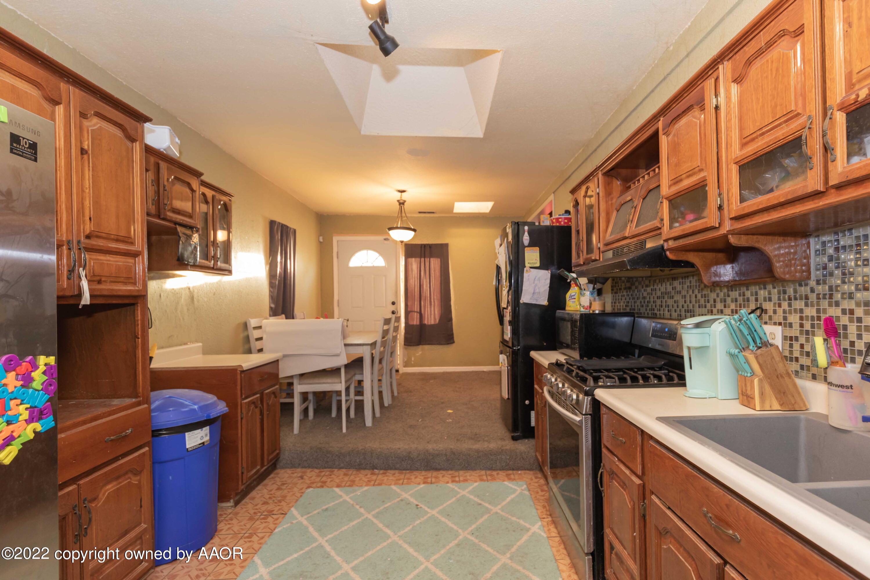 4633 South Hughes Street Amarillo, TX 79110 - Photo 13 of 23 a kitchen with stainless steel appliances granite countertop a refrigerator a sink dishwasher a stove and a dining table view
