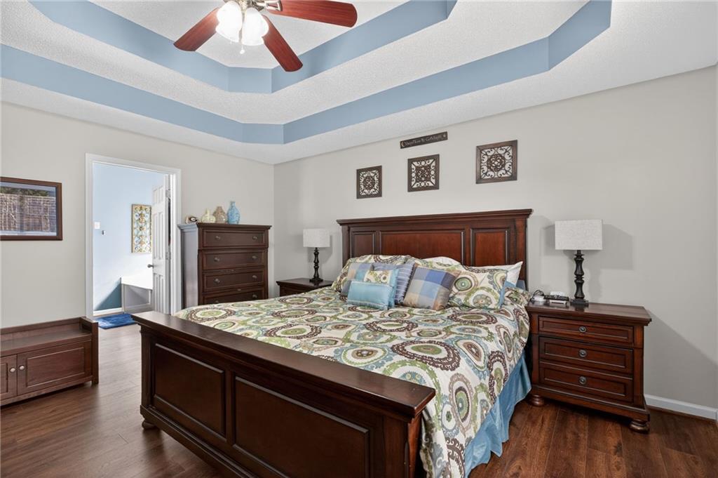 143 Autumn Run Place Villa Rica, GA 30180 - Photo 14 of 30 a bedroom with a bed and wooden floor