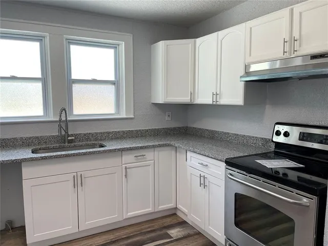 a kitchen with a sink stove and cabinets