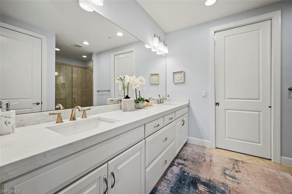 8777 Bellano Court, Unit 101 Naples, FL 34119 - Photo 13 of 39 a bathroom with double vanity sinks and a mirror