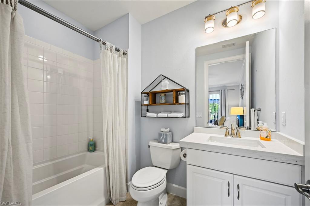 8777 Bellano Court, Unit 101 Naples, FL 34119 - Photo 17 of 39 a bathroom with a sink mirror vanity and toilet