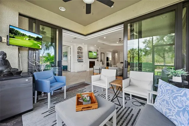 a living room with furniture a fireplace and a floor to ceiling window