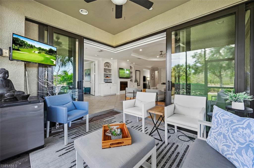 8777 Bellano Court, Unit 101 Naples, FL 34119 - Photo 20 of 39 a living room with furniture a fireplace and a floor to ceiling window