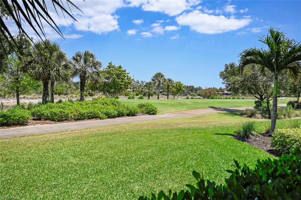 8777 Bellano Court, Unit 101 Naples, FL 34119 - Photo 25 of 39 a view of a lake with a yard