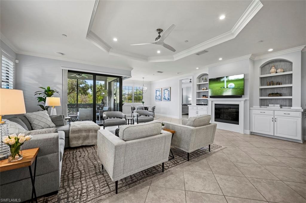 8777 Bellano Court, Unit 101 Naples, FL 34119 - Photo 4 of 39 a living room with fireplace furniture and a large window