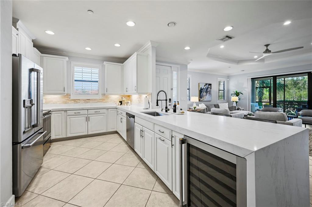8777 Bellano Court, Unit 101 Naples, FL 34119 - Photo 5 of 39 a kitchen with a sink stainless steel appliances and white cabinets