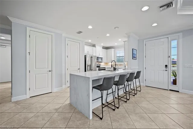 a kitchen with stainless steel appliances kitchen island granite countertop a table and chairs in it