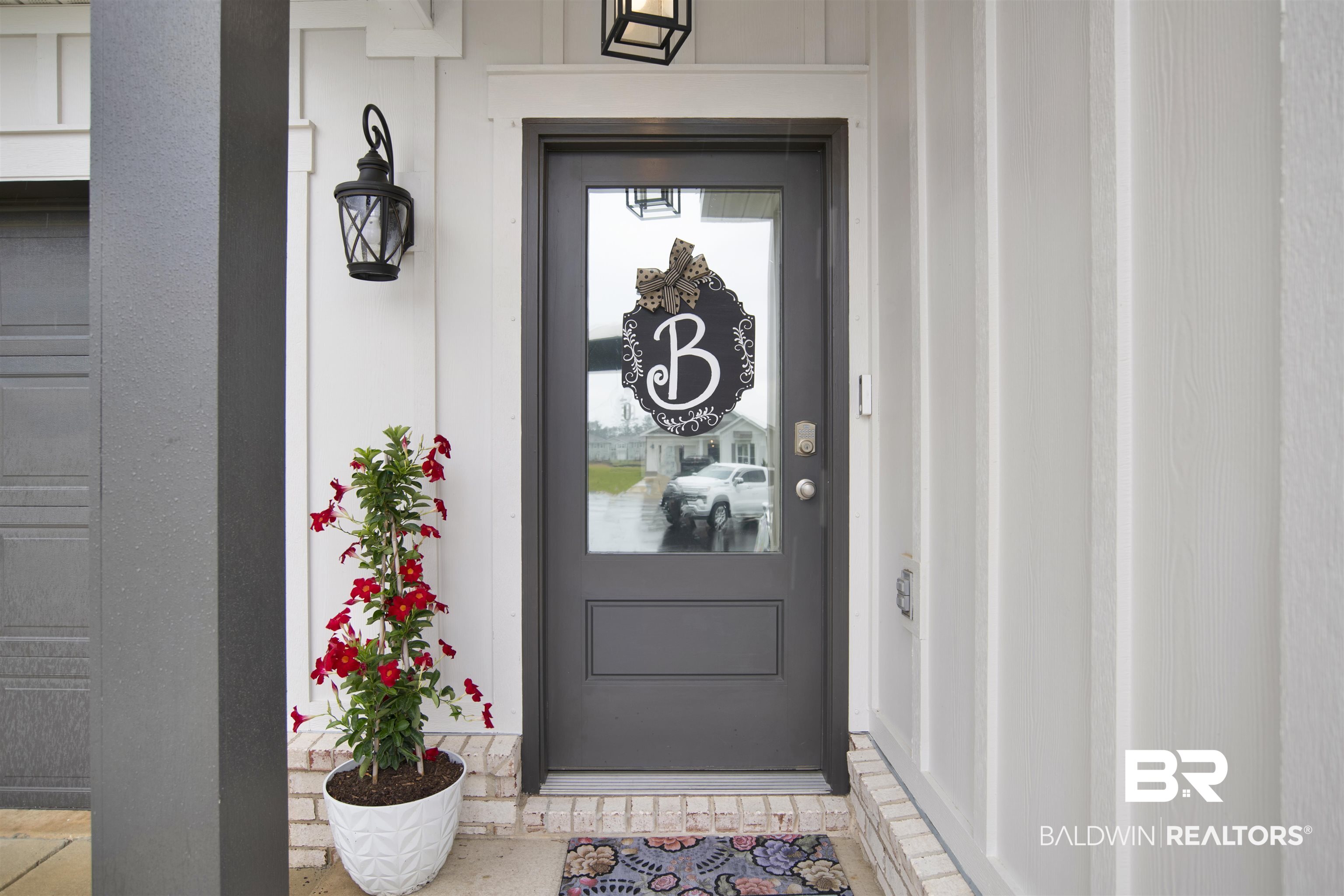 12813 Patriot Way Daphne, AL 36527 - Photo 2 of 23 Modern dark gray front door with glass paneling, flanked by white board and batten siding