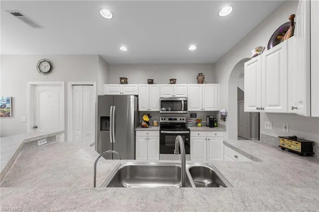 a kitchen with stainless steel appliances a stove a sink a refrigerator a window