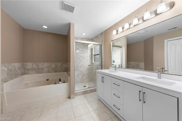 a spacious bathroom with a bathtub shower sink double and mirror