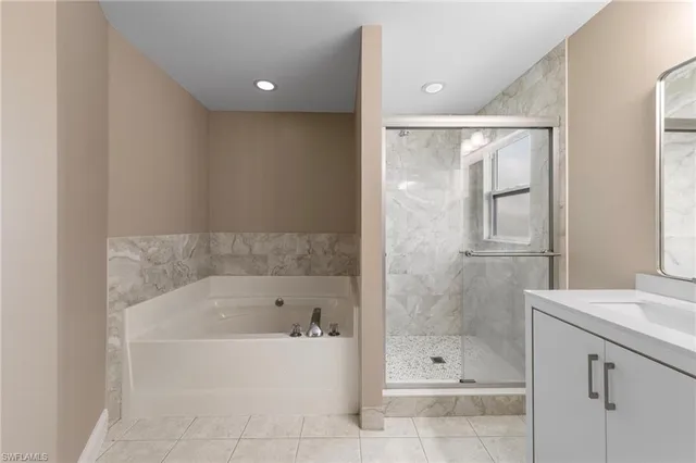 a bathroom with a bathtub shower sink and mirror