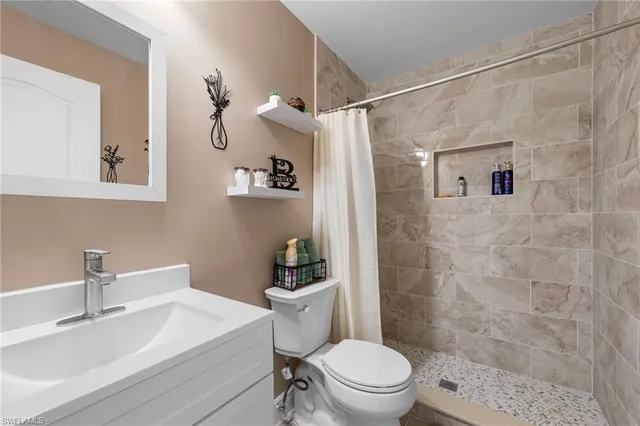 a bathroom with a sink a toilet a shower and a mirror