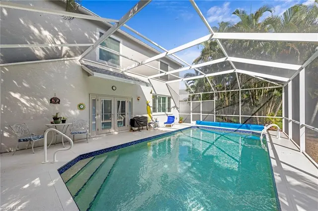 a view of a swimming pool with a patio and a yard