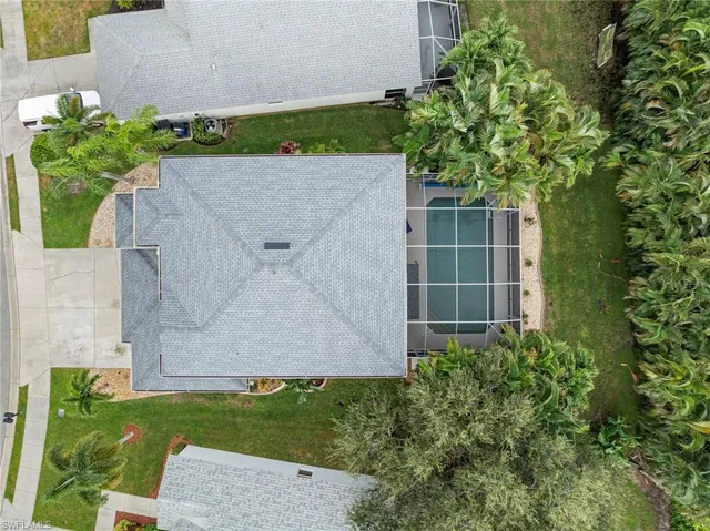 an aerial view of a house with a yard and large trees