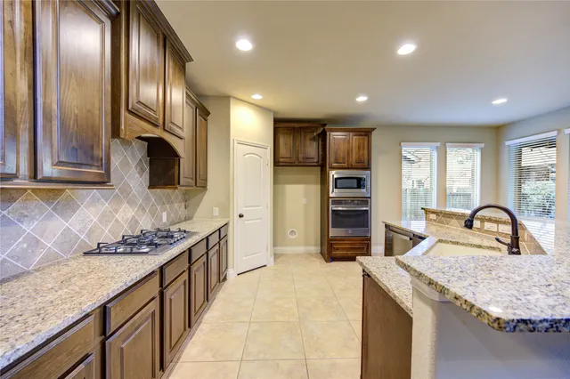 a kitchen with stainless steel appliances granite countertop a sink and cabinets