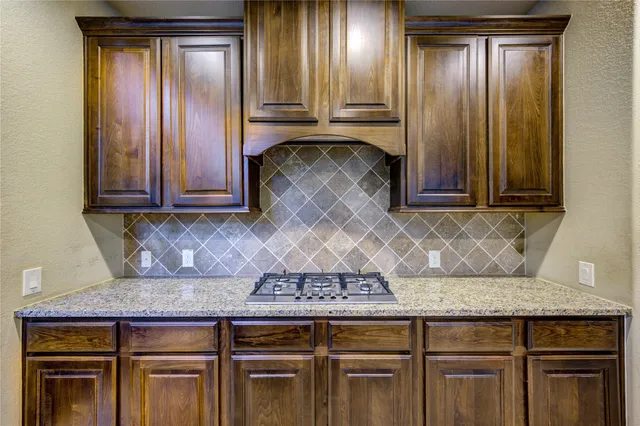 a view of a kitchen with granite countertop wooden cabinets and stainless steel appliances