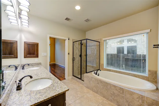 a spacious bathroom with a granite countertop tub sink and mirror