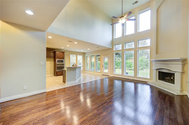 a view of an empty room with wooden floor and a fireplace