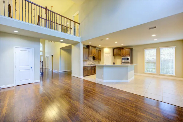 a view of an entryway with wooden floor and a kitchen