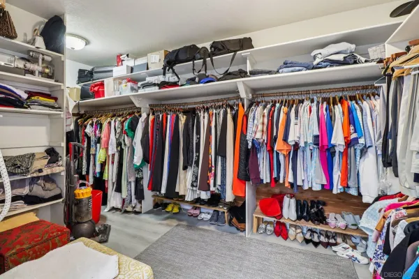 a view of walk in closet with clothes and shoes