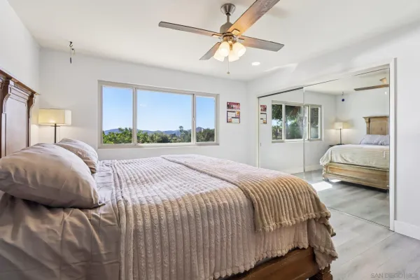 a bedroom with a bed ceiling fan and a window