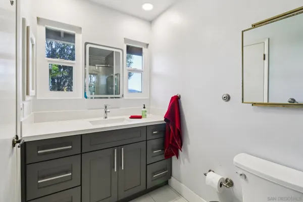 a bathroom with a sink vanity mirror and toilet
