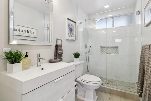a bathroom with a sink a toilet and shower