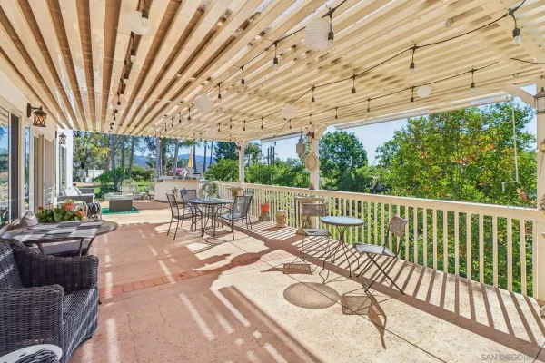 a view of a patio with couches table and chairs and potted plants