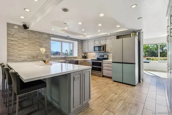 a kitchen with stainless steel appliances granite countertop a sink counter space cabinets and a refrigerator