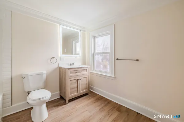 a bathroom with a granite countertop toilet a sink and mirror