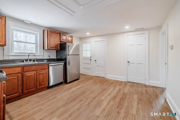 a kitchen with granite countertop a sink cabinets and wooden floor