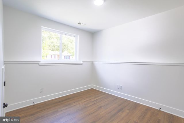 an empty room with wooden floor and window