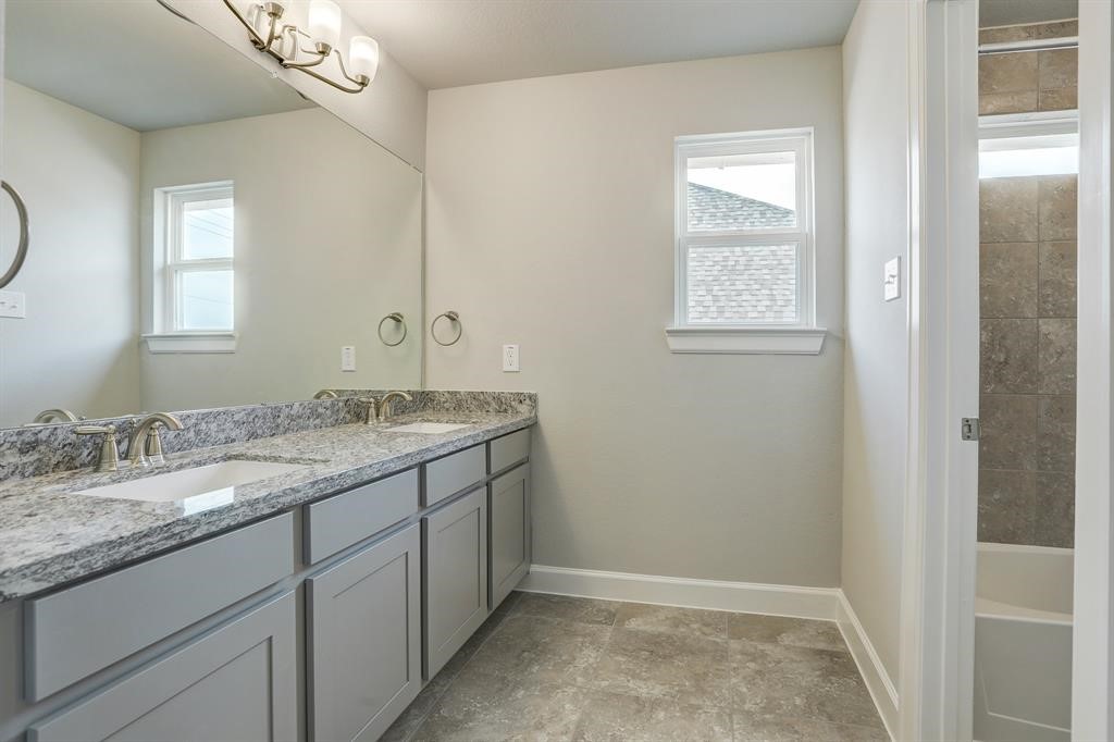 12923 Lott Avenue Houston, TX 77089 - Photo 17 of 23 a bathroom with a granite countertop sink a mirror and a window