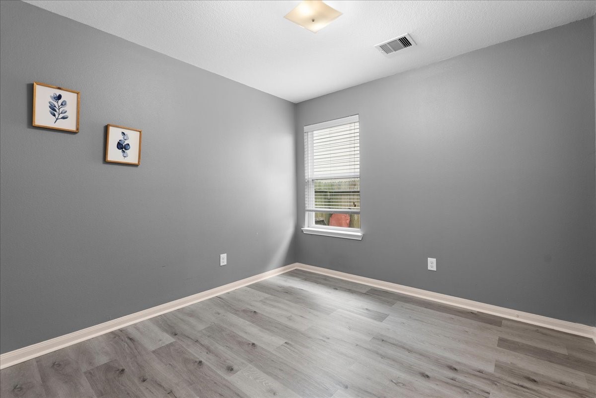 5727 Treasure Cove Road Cove, TX 77523 - Photo 11 of 20 wooden floor in an empty room with a window