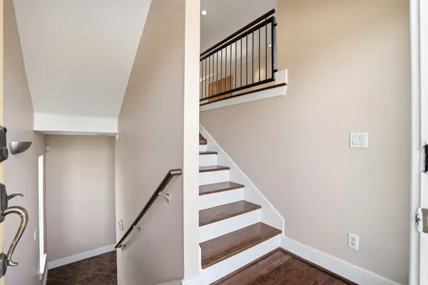 a view of staircase with white walls and railing